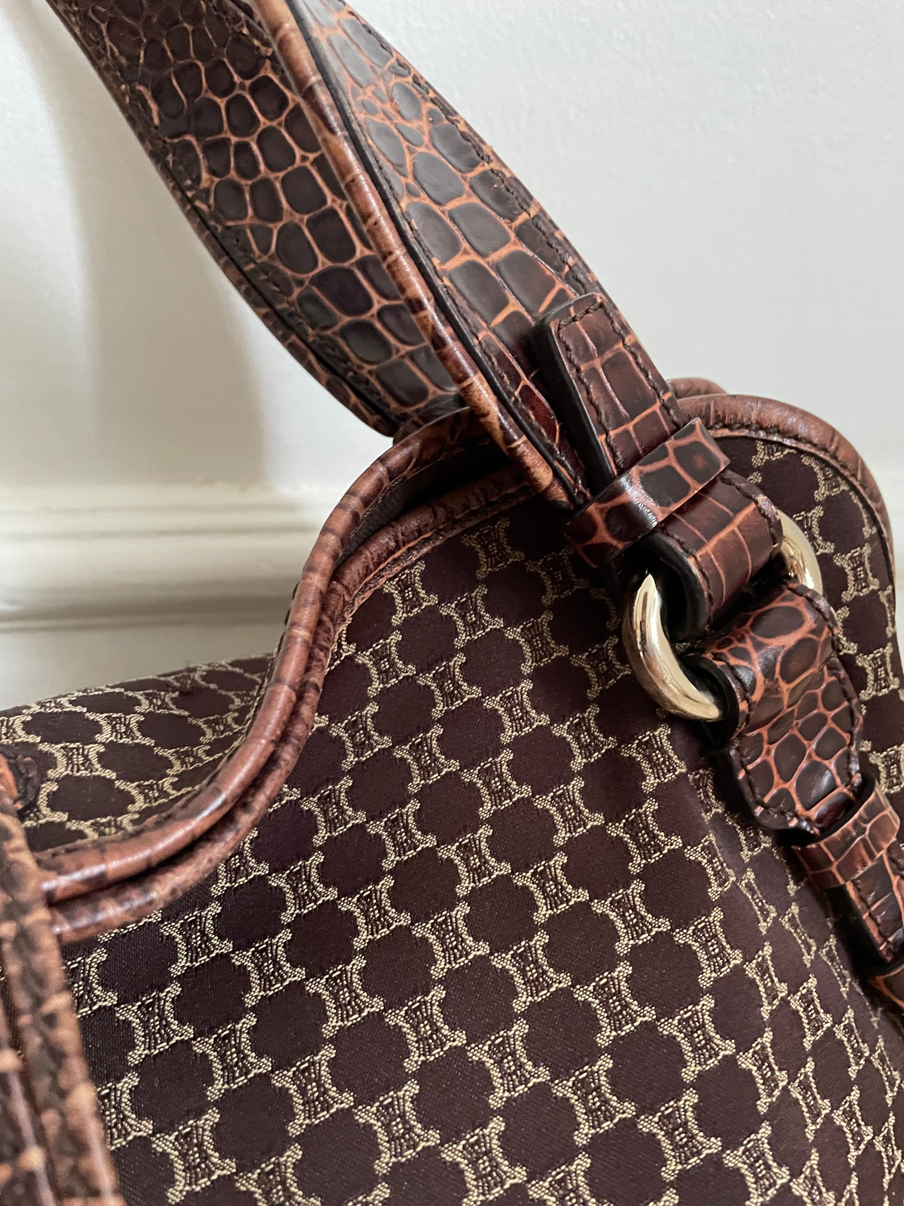 This is a Celine Macadam Bitter Sweet handbag, showcasing the brand's iconic macadam pattern. The bag features a combination of brown canvas and croc-embossed leather details, accentuated by gold-tone hardware.&nbsp;