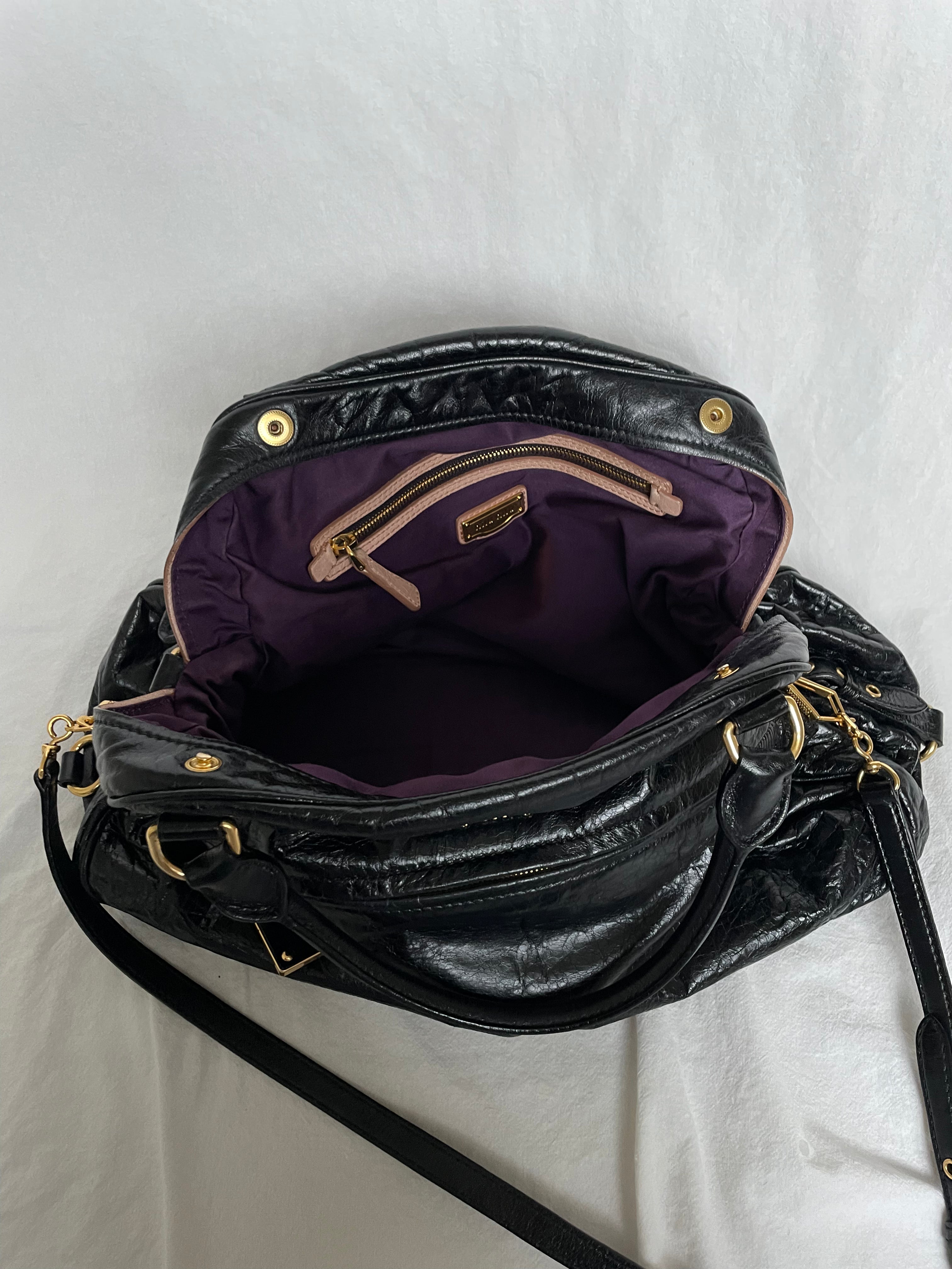 Miu Miu black nappa leather bag in a very good condition.

Crafted from nappa leather, this handbag features luxurious material and gold-tone hardware. It includes a front zip pocket, a top zip closure, and an interior slip pocket. The bag has a gold padlock charm.