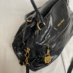 Miu Miu black nappa leather bag in a very good condition.

Crafted from nappa leather, this handbag features luxurious material and gold-tone hardware. It includes a front zip pocket, a top zip closure, and an interior slip pocket. The bag has a gold padlock charm.