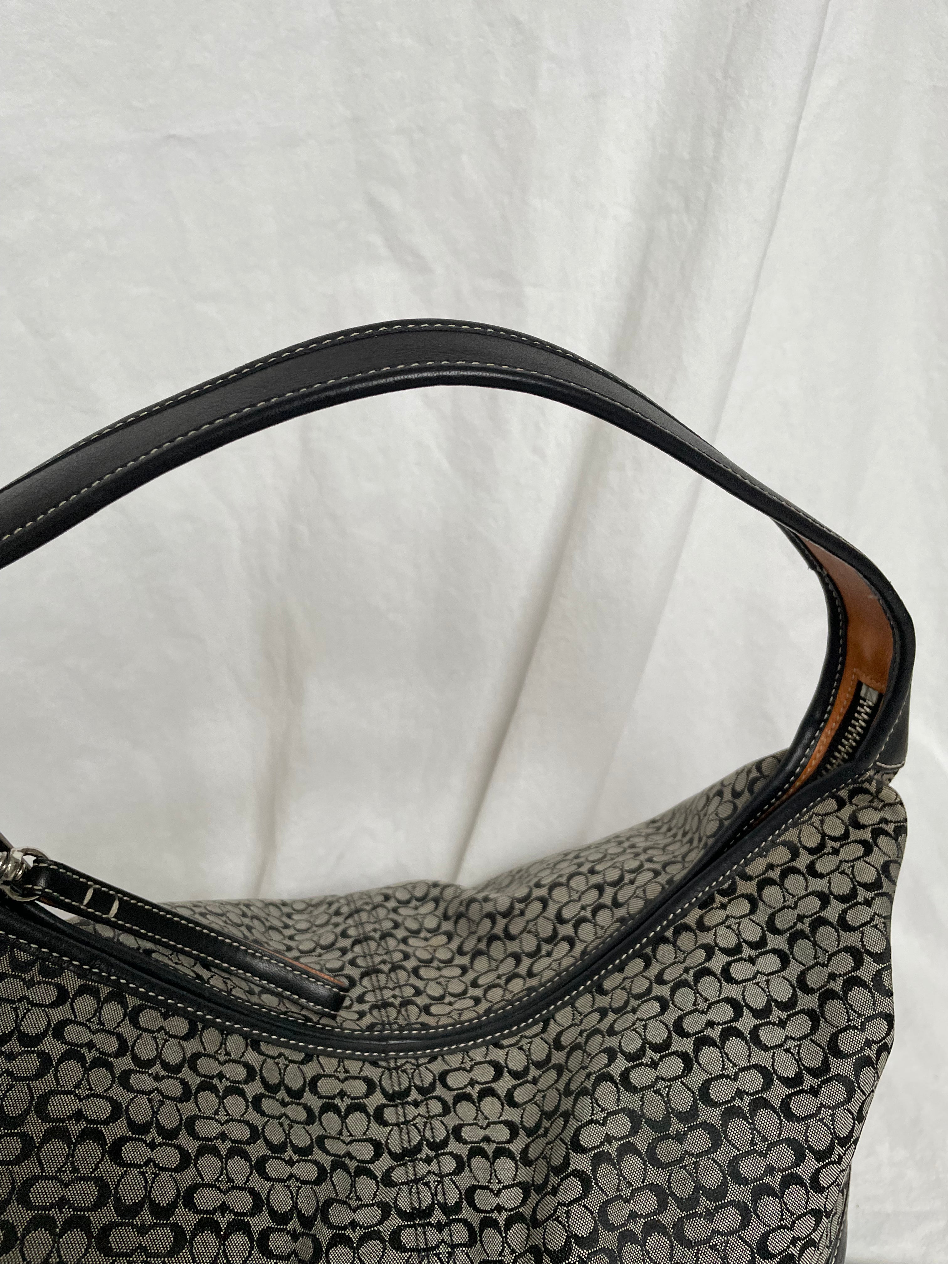 Coach shoulder bag in signature canvas and black leather, featuring one interior zip pocket. The bags condition is as good as new.