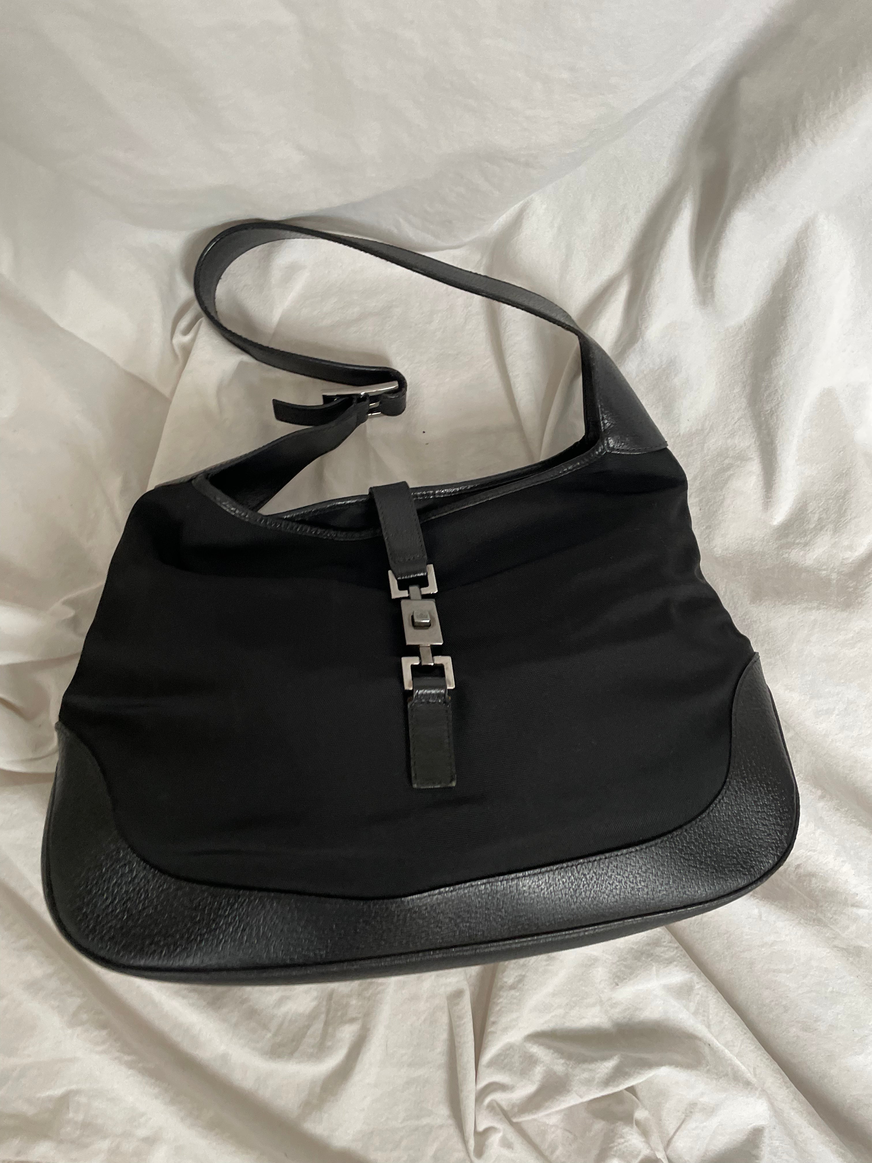 A vintage Gucci Jackie in black leather and nylon. The bag features a stylish buckle closure and a spacious interior. A timeless design perfect for any occasion.