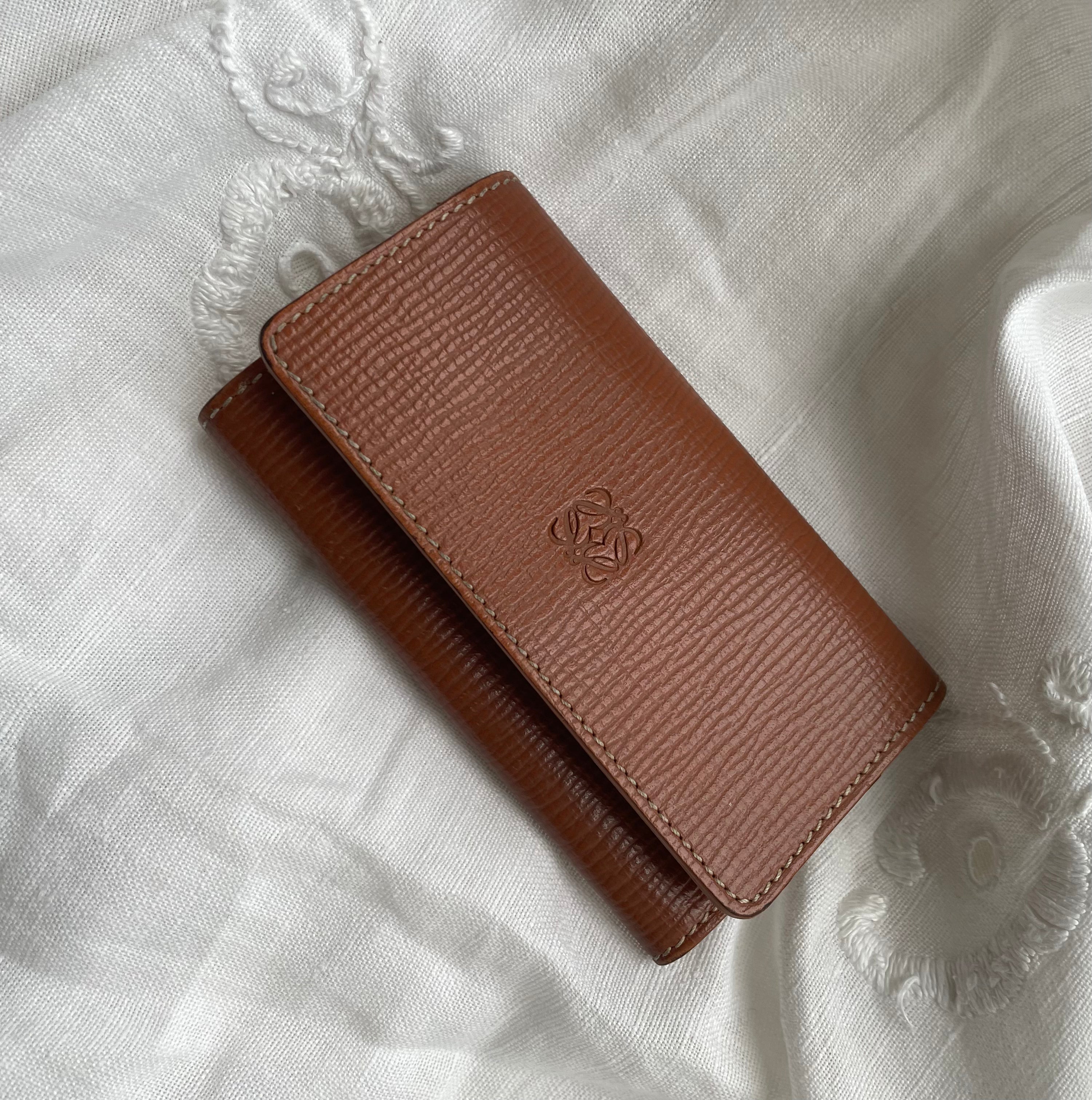 Beautiful Loewe key wallet in brown leather with white stitching. The key wallet is in a good condition and has room for 6 keys.