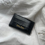 Miu Miu key wallet in black leather. Shows minor signs of wear on the hardware, but overall in very good condition