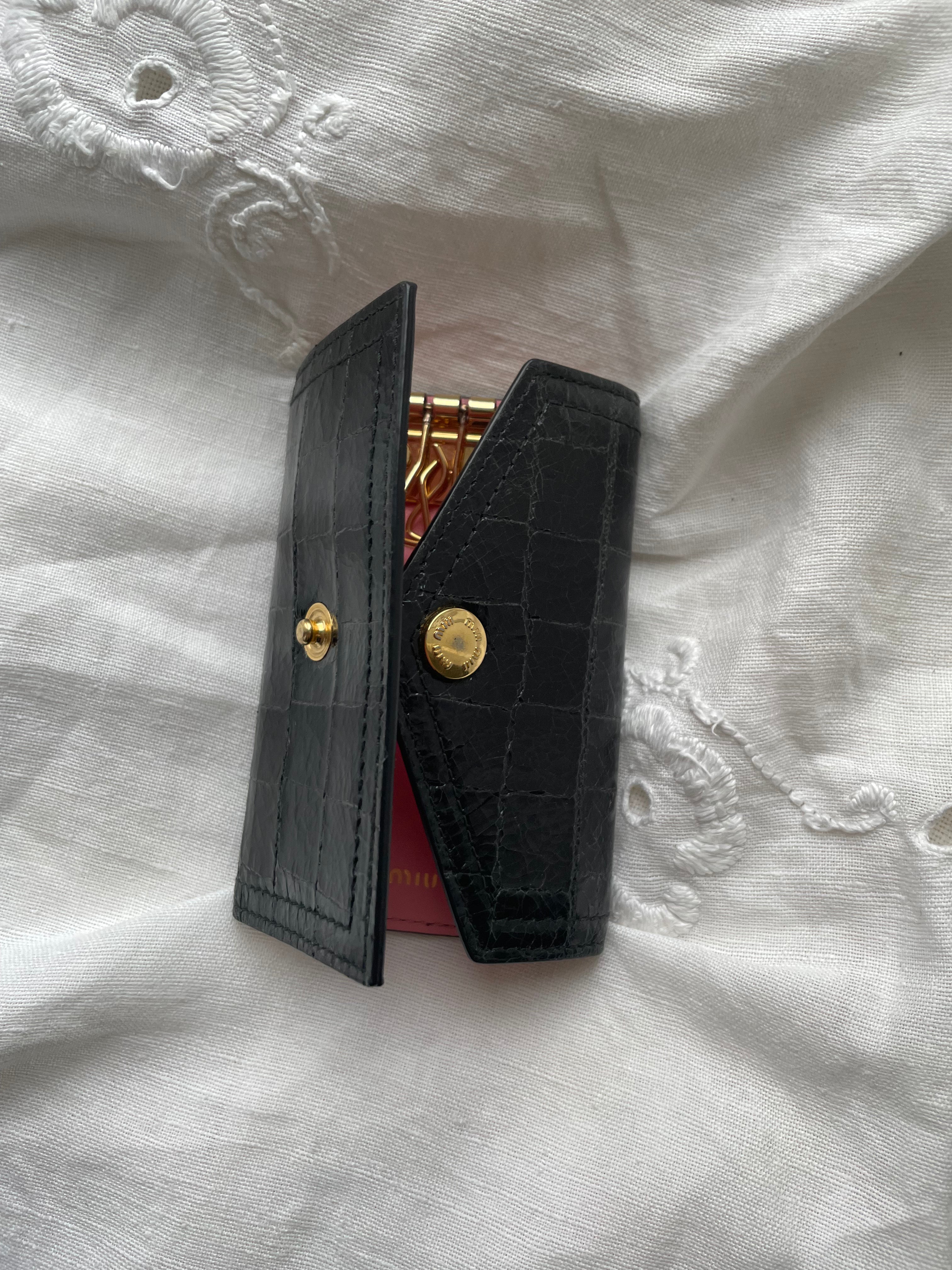 Miu Miu key wallet in black leather. Shows minor signs of wear on the hardware, but overall in very good condition