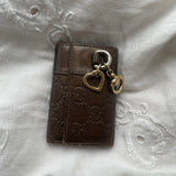 Gucci key wallet in brown leather with iconic monogram and a cute silver charm.