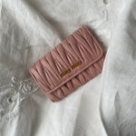 Miu Miu wallet in soft pink leather with a signature matelassé pattern.