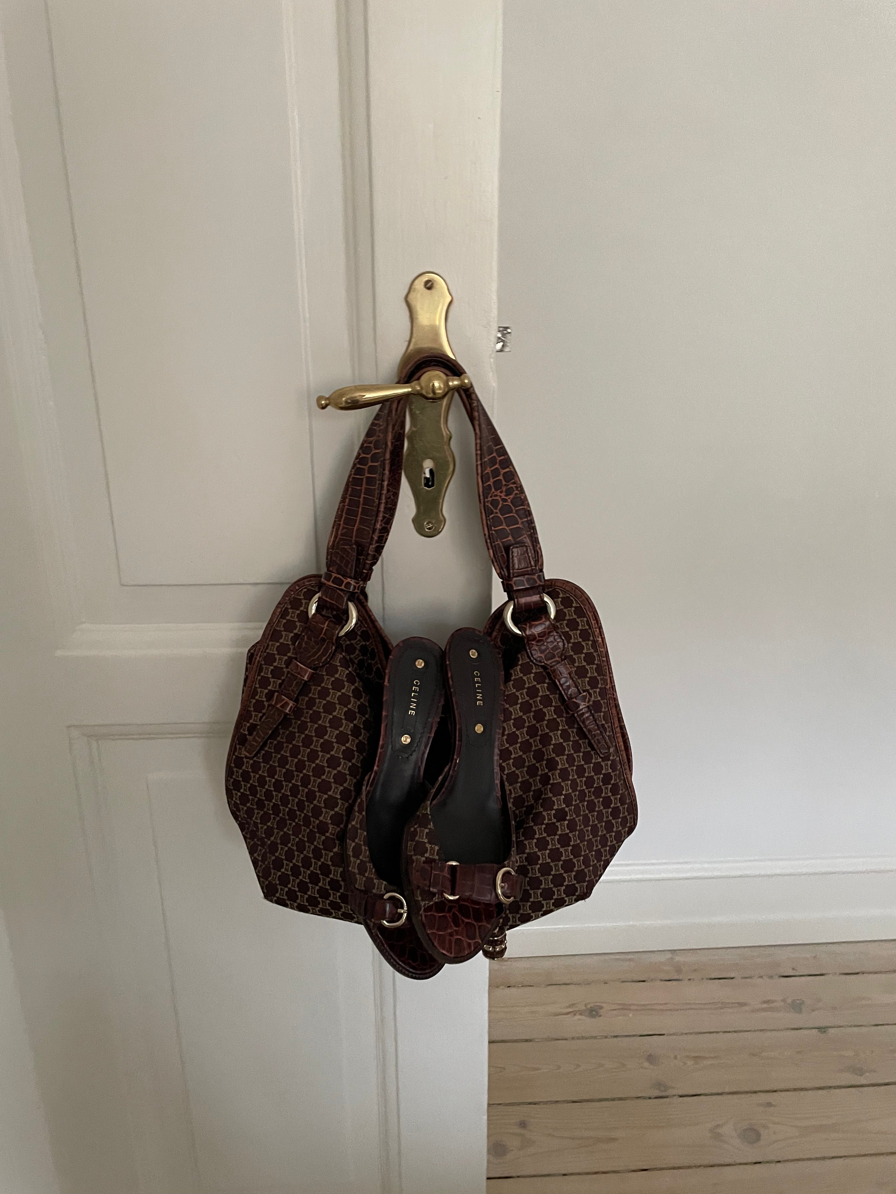 This is a Celine Macadam Bitter Sweet handbag, showcasing the brand's iconic macadam pattern. The bag features a combination of brown canvas and croc-embossed leather details, accentuated by gold-tone hardware.&nbsp;